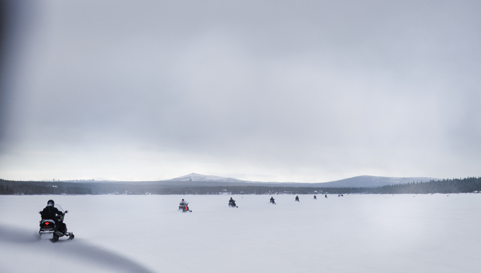 Sneeuwscooters over het bevroren meer van Jukkasjärvi